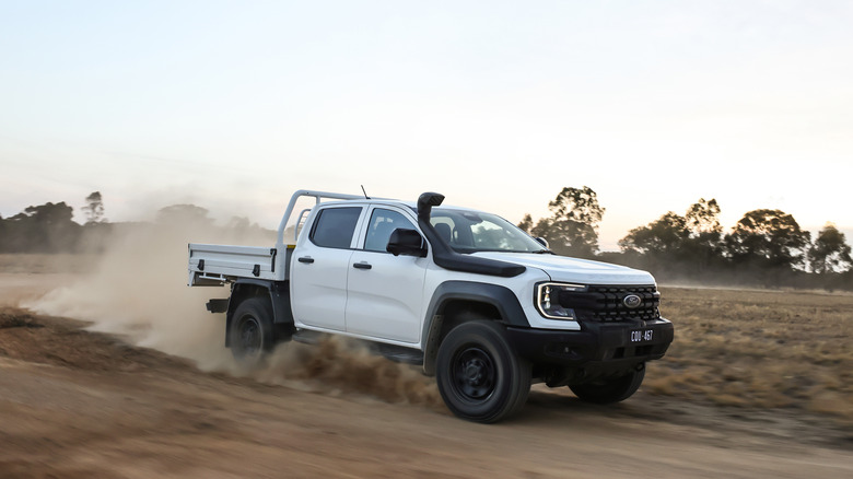A white Ranger Super Duty driving on dirt