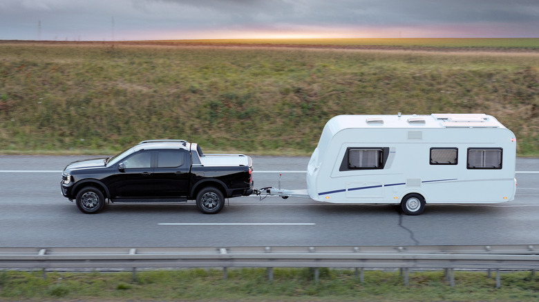 Family Vacation Trip On Black Pickup Truck With White Camper Trailer